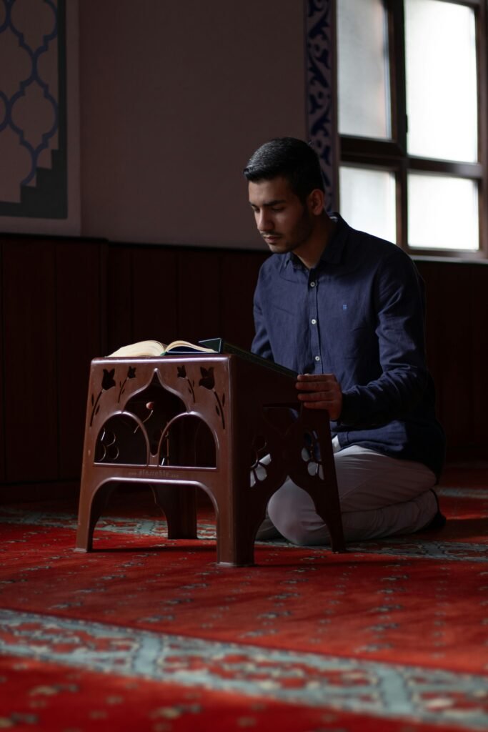 pexels-photo-30890548-30890548 A young man engaging in prayer inside a mosque with natural light.