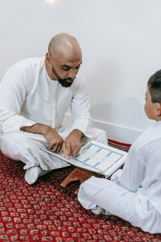 pexels-photo-9127780-9127780 Father and son reading religious text together, fostering faith and learning.